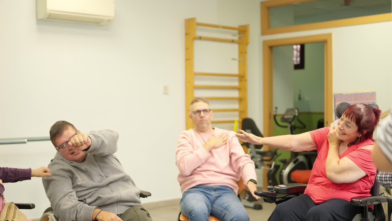 Gruppo di persone disabili che fanno esercizi per le braccia in un centro di riabilitazione
