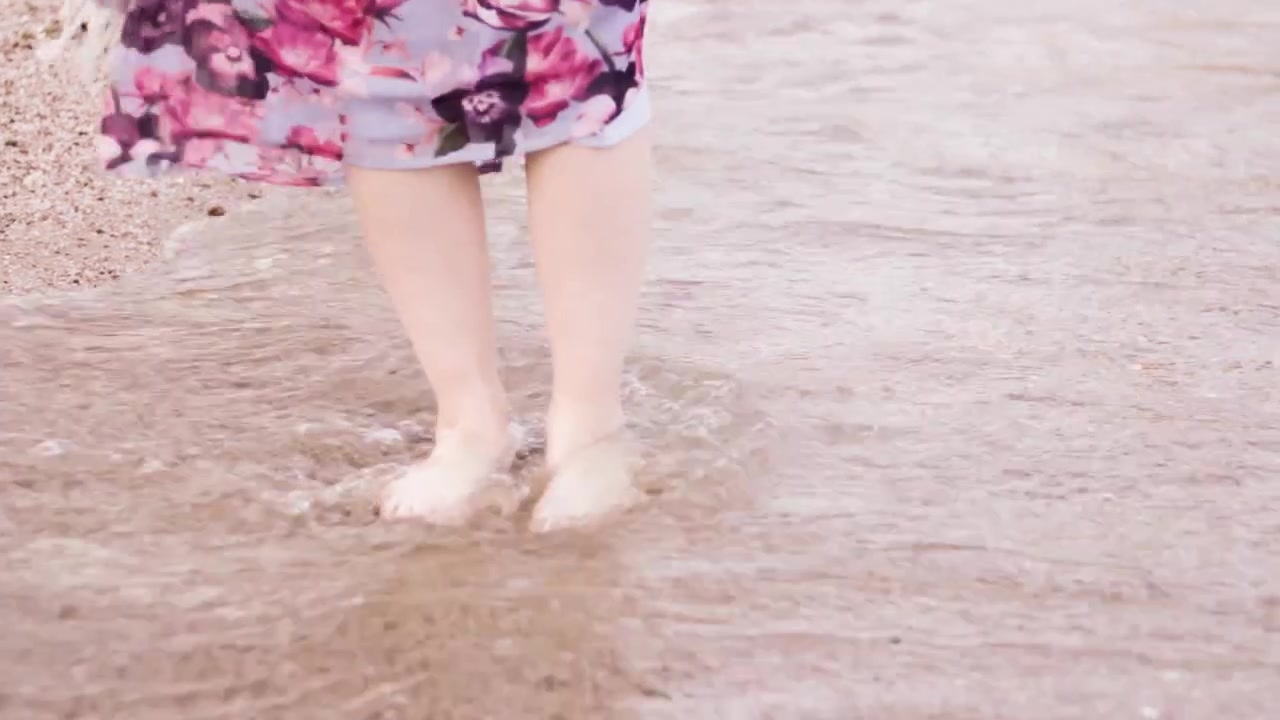 Ragazza in piedi sulla spiaggia nell'acqua con onde e sabbia. Viaggio in Egitto, Hurghada