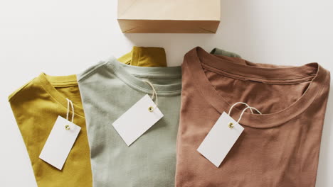 video de primer plano de camisetas plegadas con etiquetas en fondo blanco