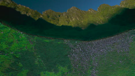 Wide-drone-shot-of-lake-reflecting-Mountain-range-and-greenery-Nepal,-crystal-clear-view-4K