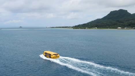 yellow boat traveling on calm ocean waters near lush island