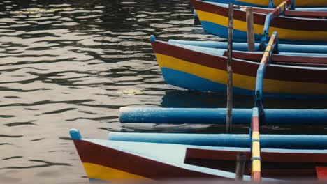 los barcos de pesca tradicionales indonesios llamados jukung se sientan amarrados en el río