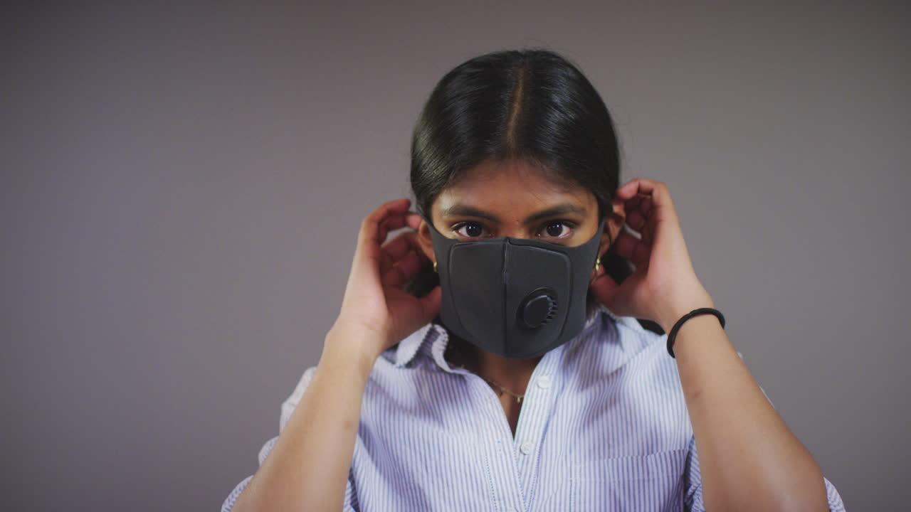 젊은 여자는 얼굴 마스크 팬 복사 공간에 둔다