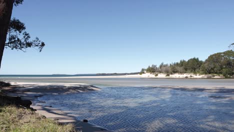 creek beach shore at moona moona australia mixing with jervis bay waters in australia, locked shot