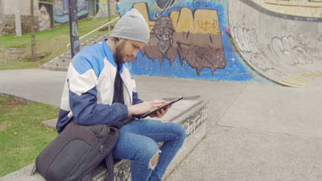 young man using tablet in a park