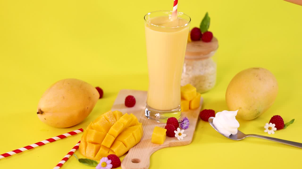 Mango smoothie, fresh fruit, and whipped cream arranged on cutting board with bright, even lighting