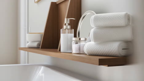 organized bathroom shelf with white towels and toiletries