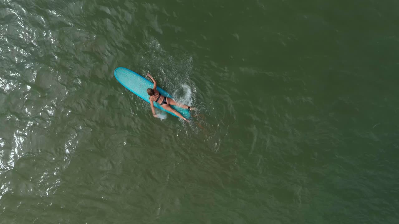 vista de pájaro de una surfista en el golfo de méxico frente a la costa del lago jackson en texas