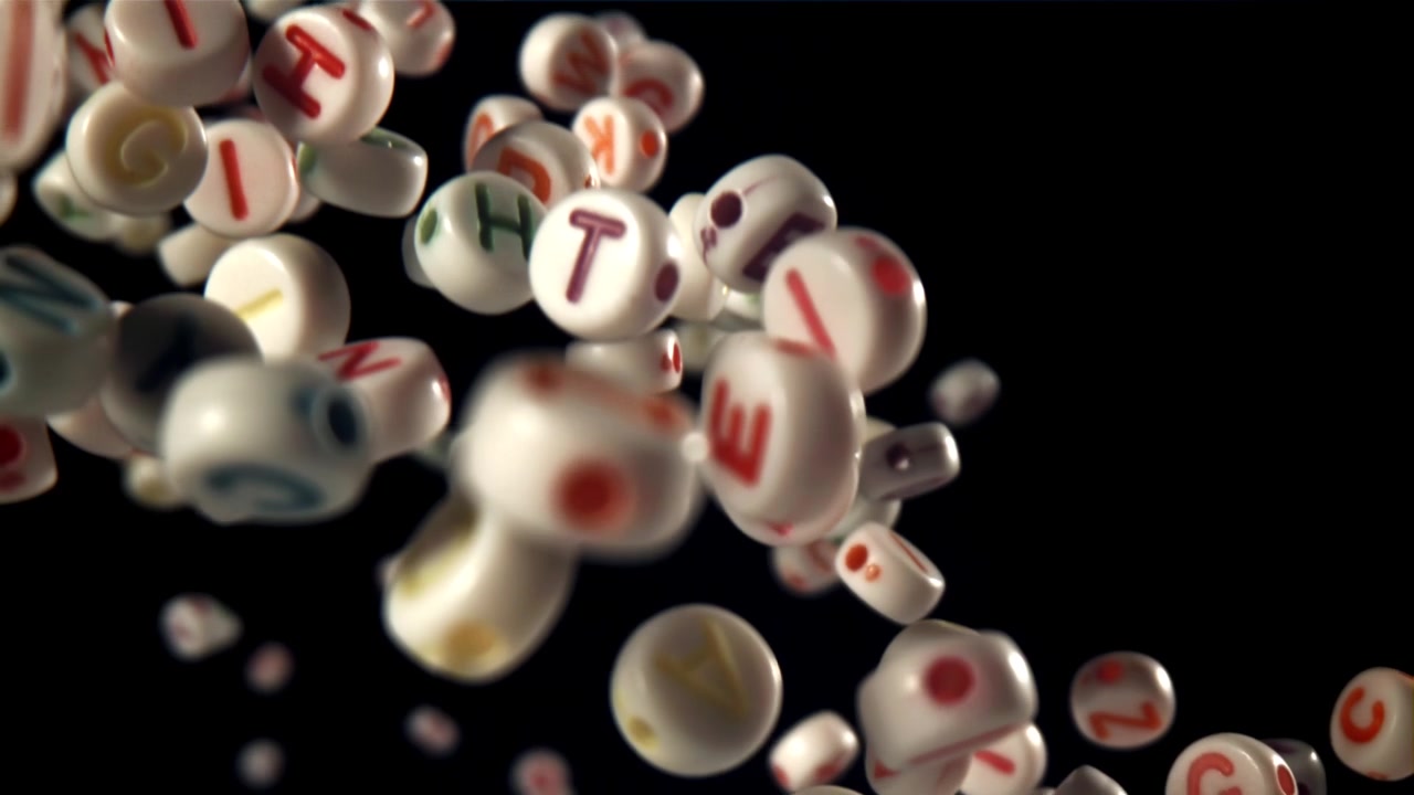 Farverige alfabetperler falder i slow motion