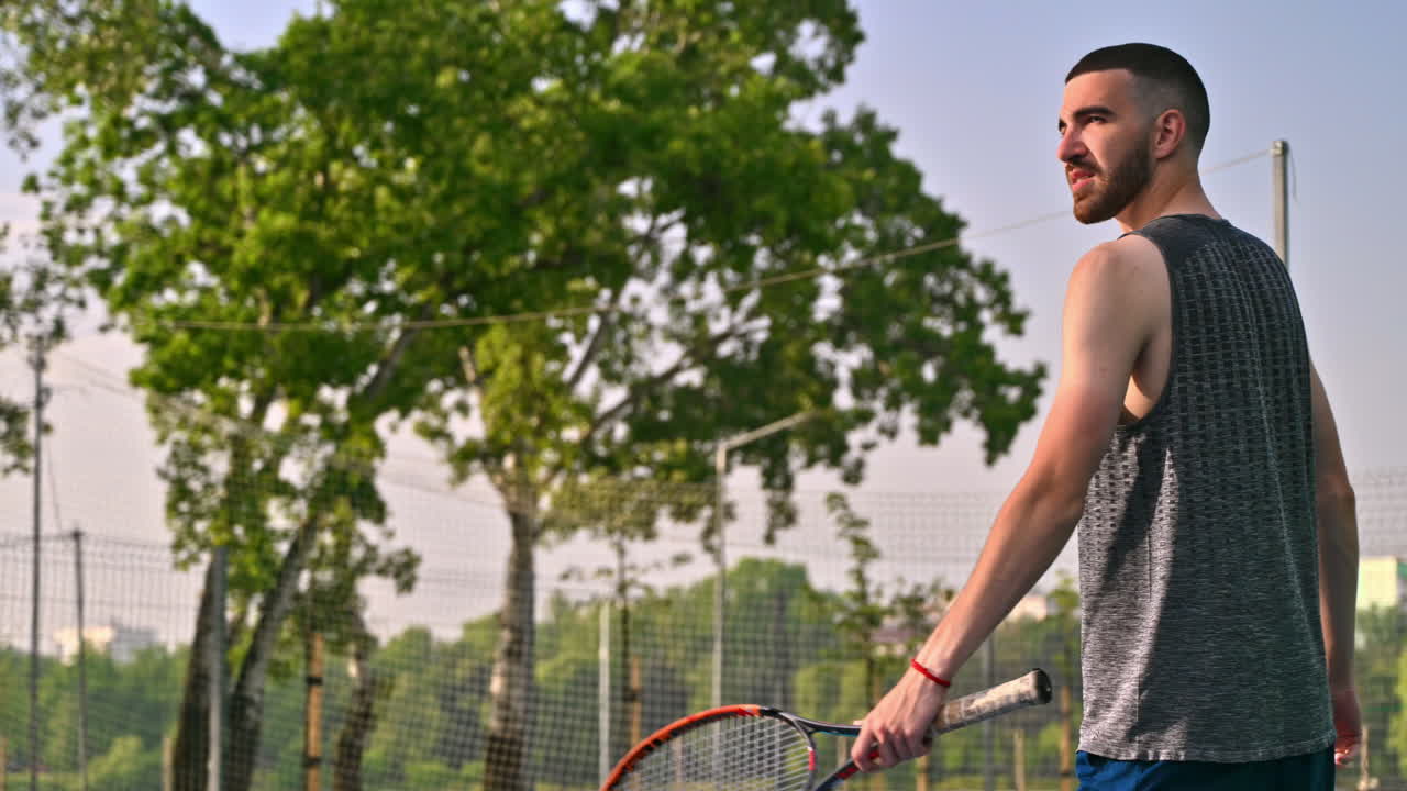 Man playing tennis at sunrise, after rain