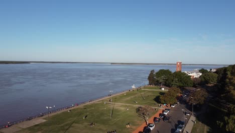 beautiful aerial view of the coast of rosario argentina at the afternoon people and familys enjoy the sun along the coast of the parana river with a beatyful blue sky at the background