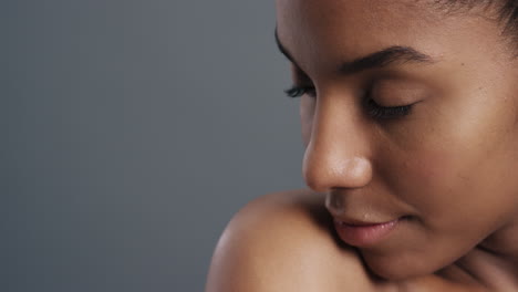 close up portrait beautiful african american woman touching bare shoulders with hands enjoying smooth healthy skin complexion perfect natural beauty on grey background