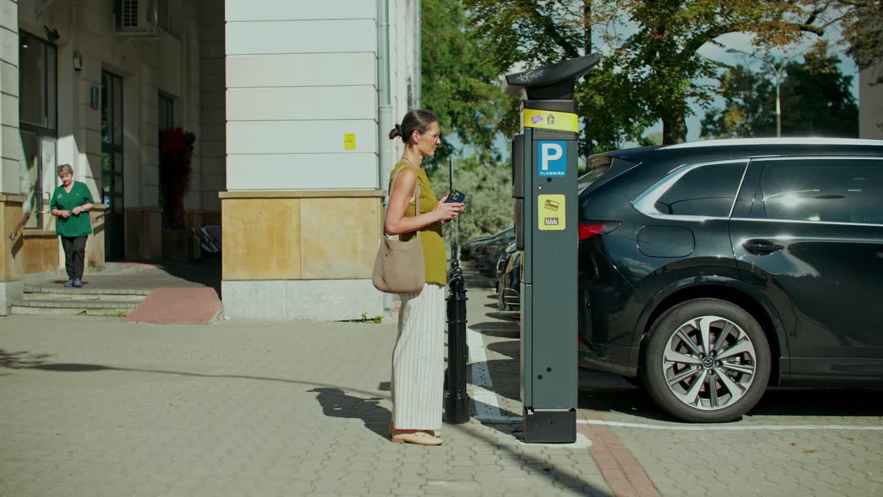 Женщина платит за парковку в паркомате