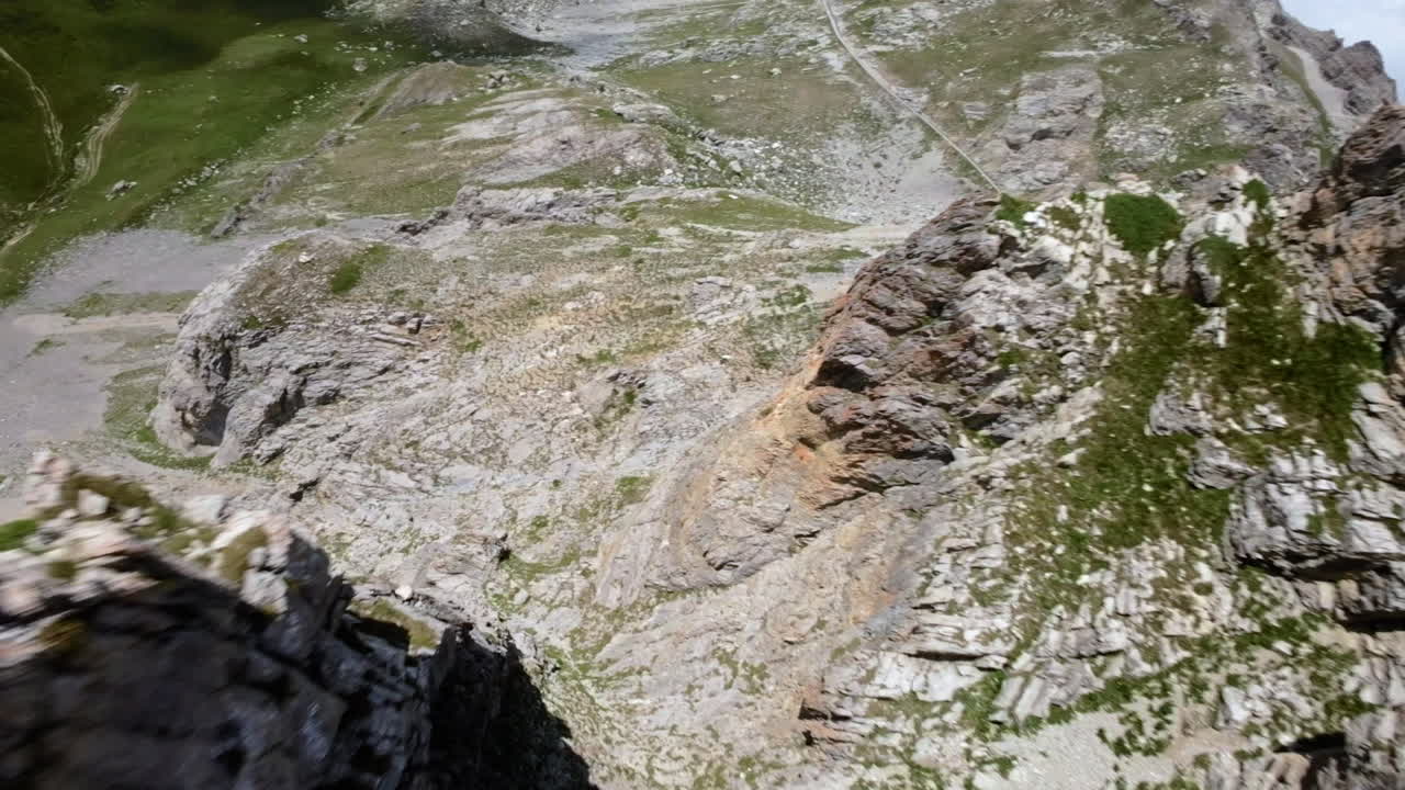 Rocky mountain landscape under a bright blue sky with scattered clouds