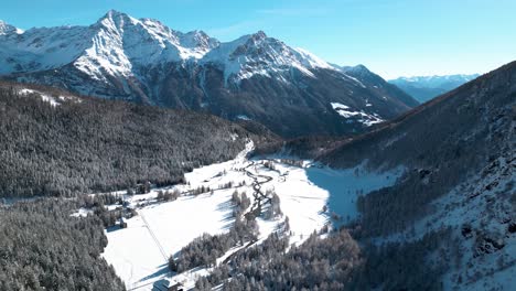 aerial view of snow covered mountain landscape with forests and rivers on a sunny winter day in alp grum, switzerland