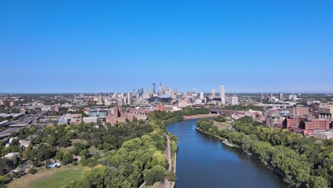 Eine-Drohnen-Luftaufnahme-Der-Skyline-Von-Minneapolis-Direkt-Flussaufwärts-Des-Mississippi