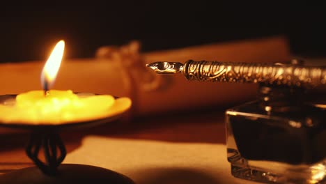 vintage quill pen and inkwell on old parchment paper in candlelight