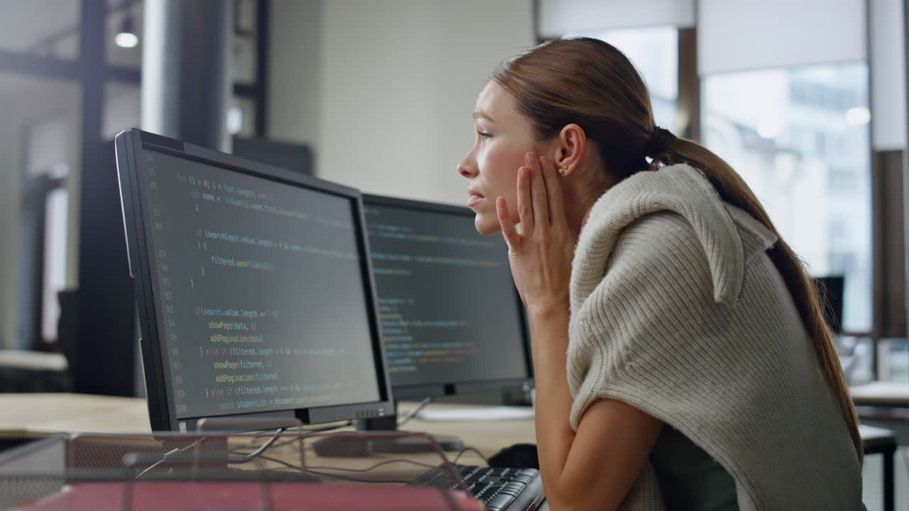 Exhausted developer working office alone. Stressed woman rubbing head searching