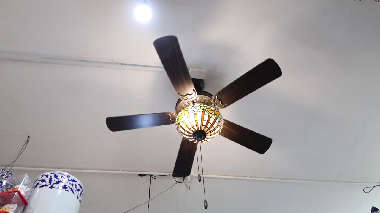 ventilador de techo girando bajo una luz
