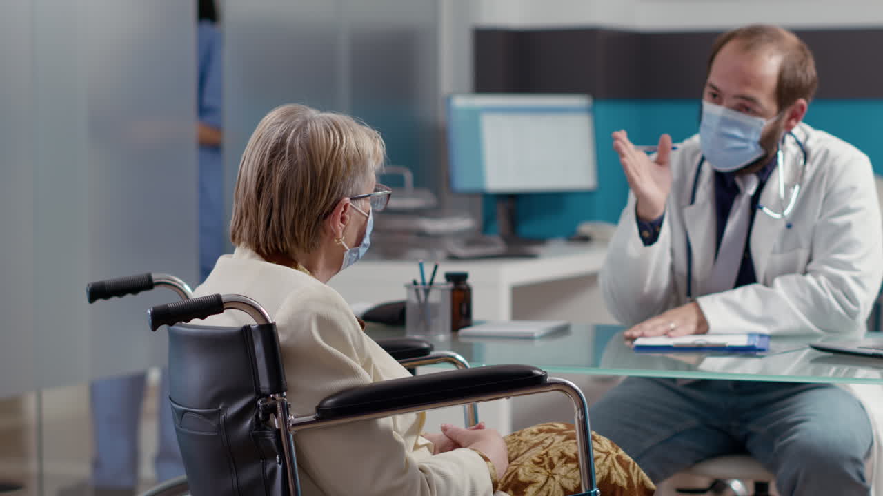 Elder patient with physical disability talking to doctor