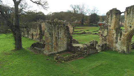 Basingwerk-abbey-landmark-medieval-abandoned-Welsh-ruins-Aerial-view-pull-back-orbit-left