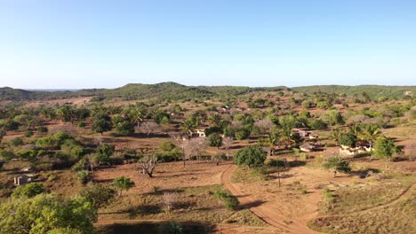 aerial tilt-down cinematic shot of chidenguele village showcasing traditional african huts and plantations