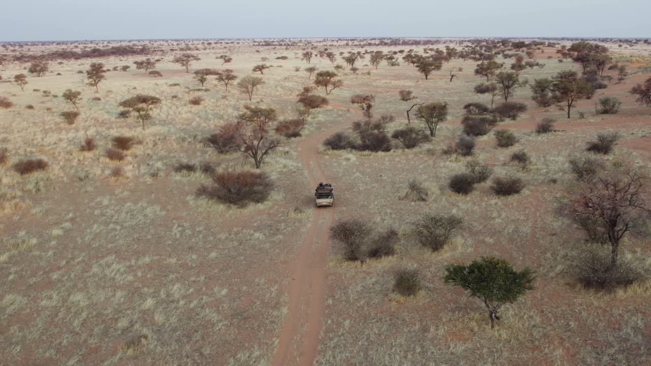 conducción de vehículos todoterreno en la carretera en medio del desierto en namibia, áfrica