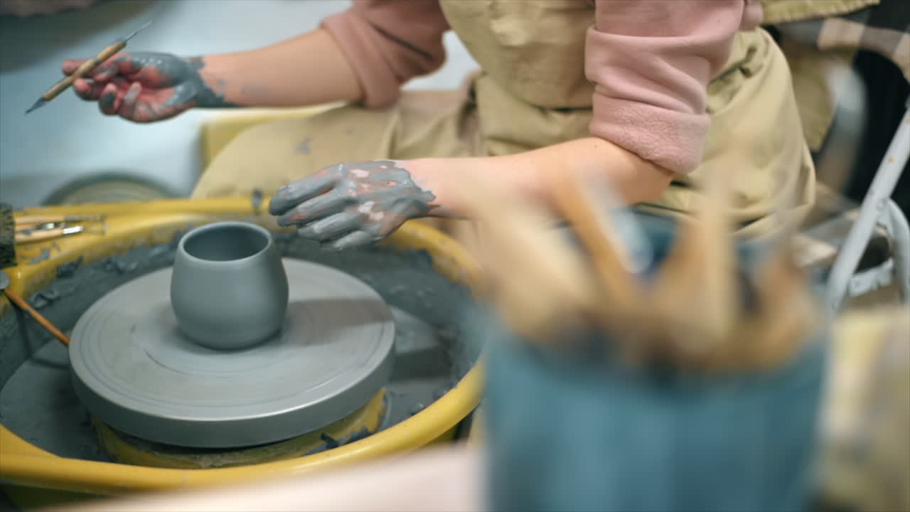 The master of sculpting pottery working and tools in a studio. Shaping the clay on the potter's wheel. Slow motion