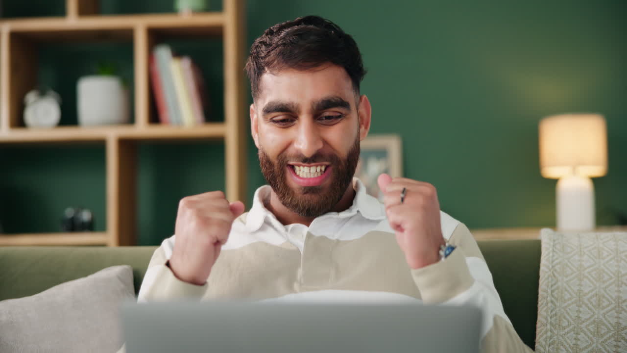Man celebrating in front of laptop