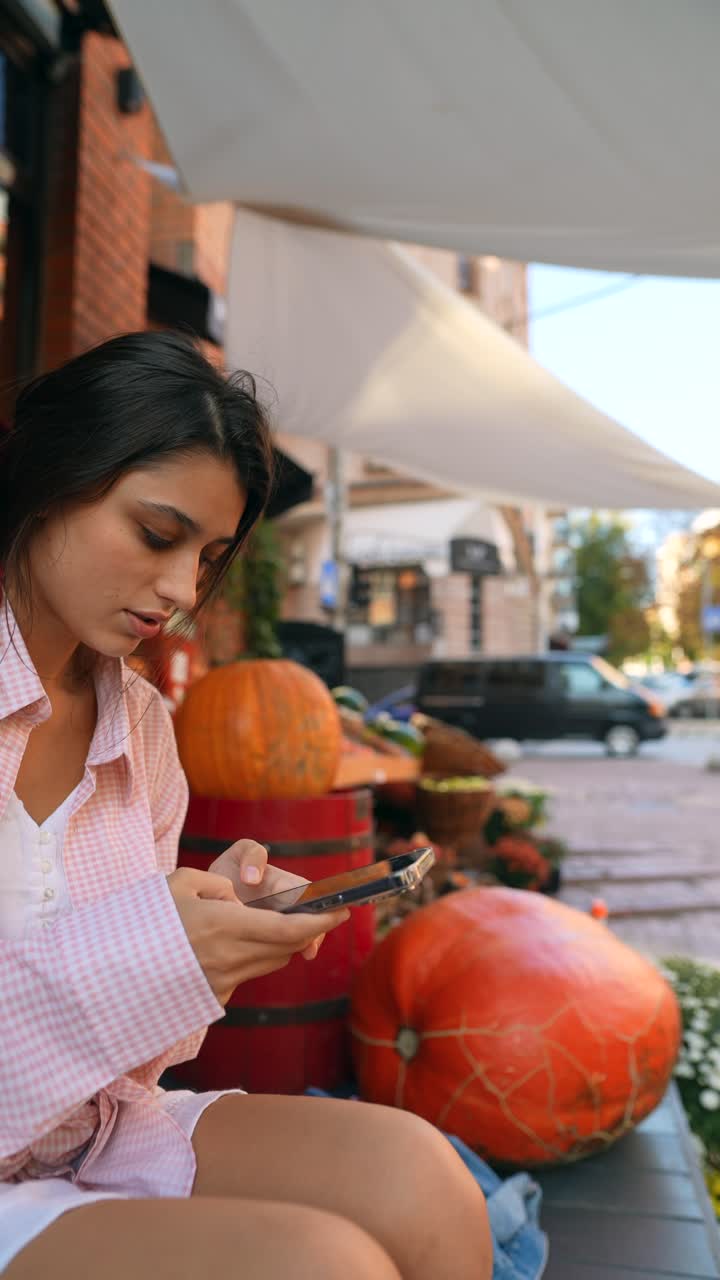 mujer joven usando el teléfono en un mercado al aire libre