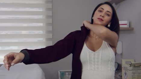 doctora hispana en su oficina poniéndose su delantal para el trabajo - cámara lenta