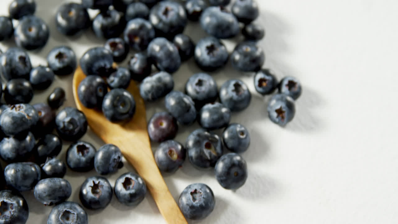 Blueberries with wooden spoon on white background 4K 4k