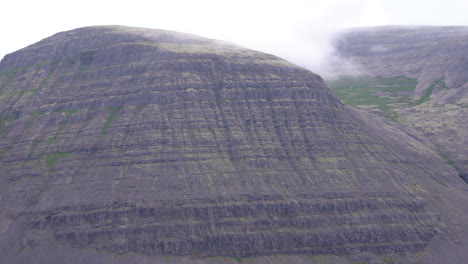 Pan-right-shot-of-volcanic-icelandic-mountain-covered-with-moss