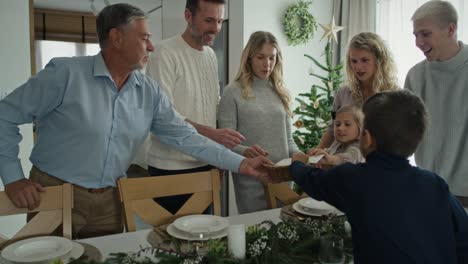 familia caucásica compartiendo la hostia para desear en navidad.
