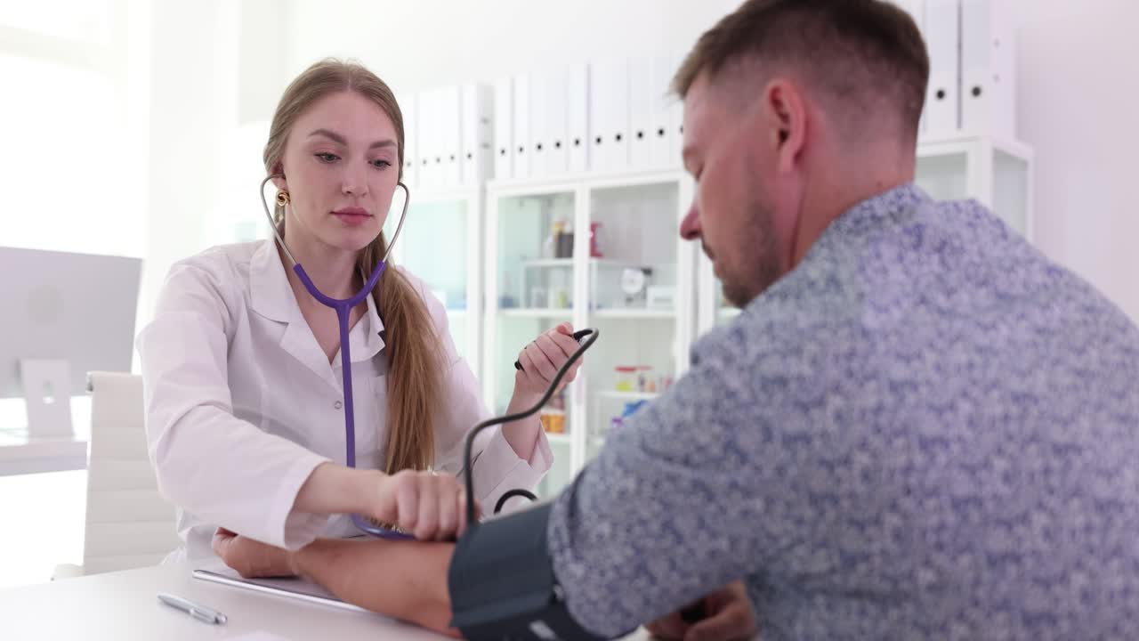 A doctor measures a patient's blood pressure during a medical check-up