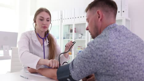 a doctor measures a patient's blood pressure during a medical check-up