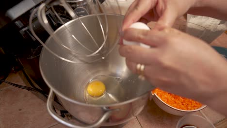 breaking and puting eggs into the bowl, then beat them for a cake