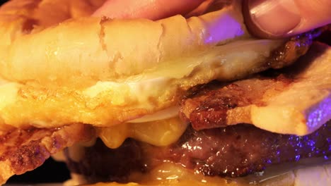 juicy egg yolk drips from a burger, close up view