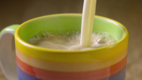 Acercar,-La-Leche-De-Avena-Espumosa-Se-Vierte-En-Una-Taza-Humeante-De-Colores,-60-Fps