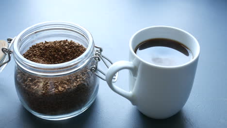 panning shot of fresh coffee in a white cup sitting on a table top counter in a kitchen