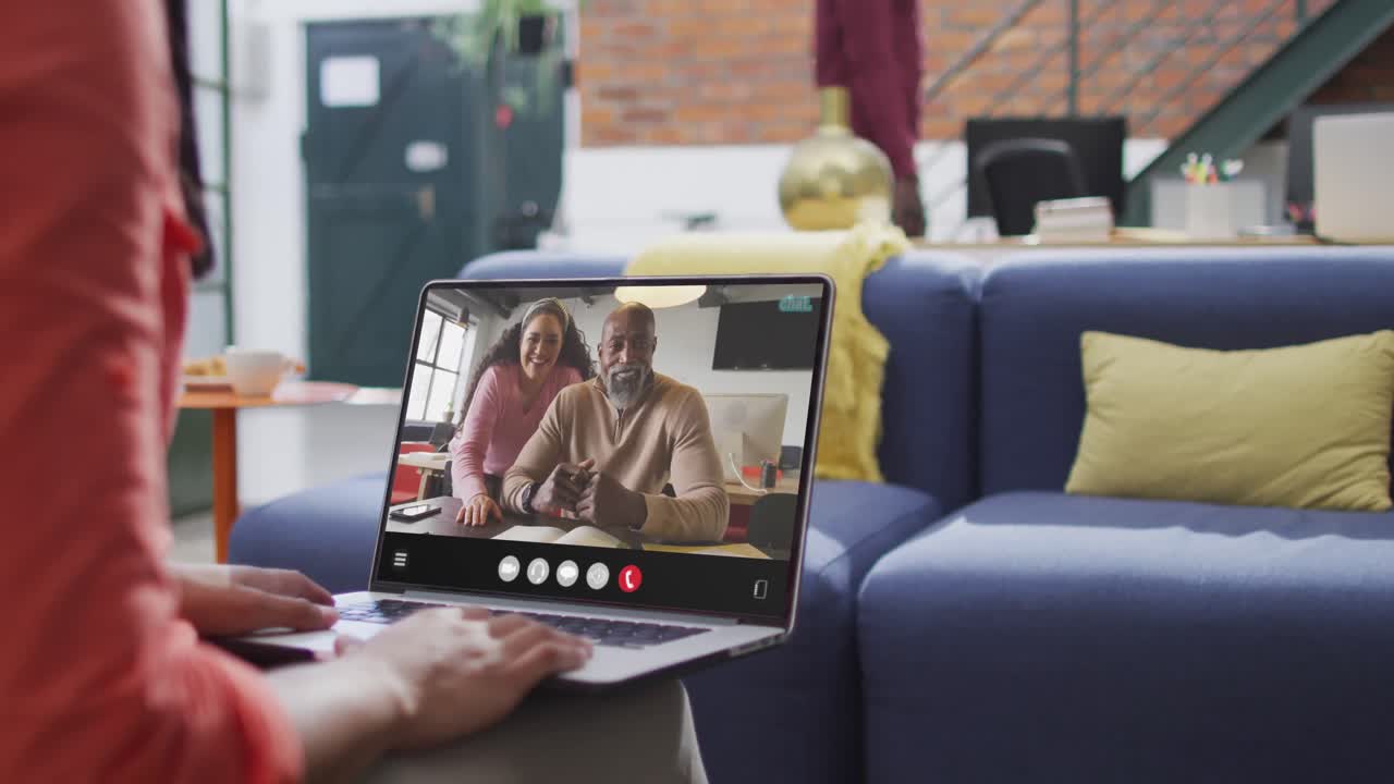 Donna birazziale che usa il laptop per una videochiamata, con diversi colleghi di lavoro sullo schermo