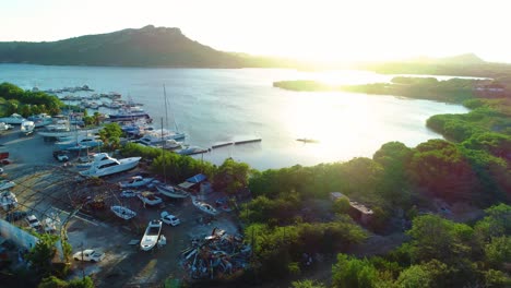 Drone-trucking-pan-overview-of-piscadera-bay-at-sunset,-long-shadows-and-golden-glow