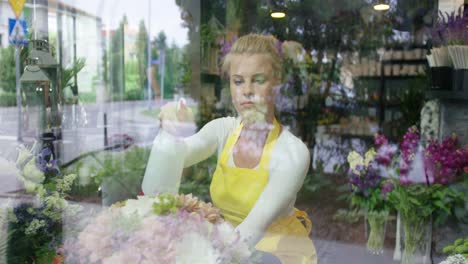 woman sprinkling flowers in shop