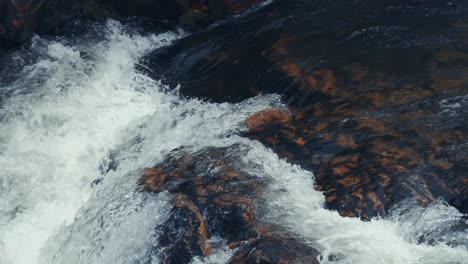 water rushes over the dark rocks