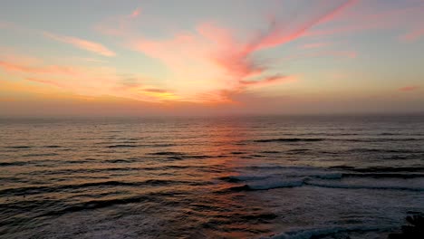 vista aérea de la puesta de sol de las olas rompiendo en una hermosa playa en san diego, california