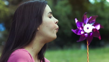 woman breathing on a pinwheel in slow motion