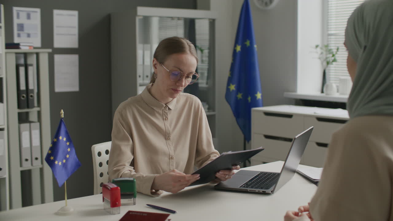 Female Consular Officer Interviewing Woman in Hijab at EU Embassy