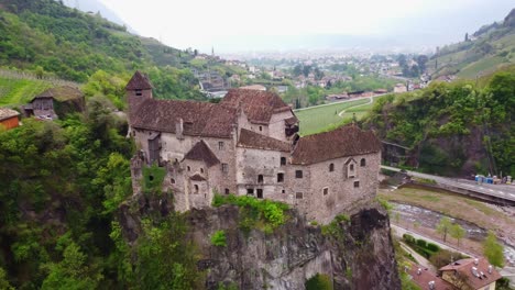 drone circles above roncolo castle in south tyrol, revealing the stunning natural surroundings