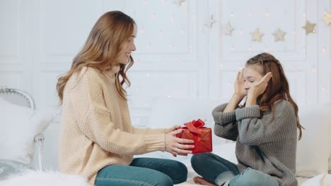 Fröhliches-Mädchen-Bekommt-Neujahrsgeschenk-Im-Schlafzimmer.-Glückliche-Mutter,-Die-Geschenk-überreicht