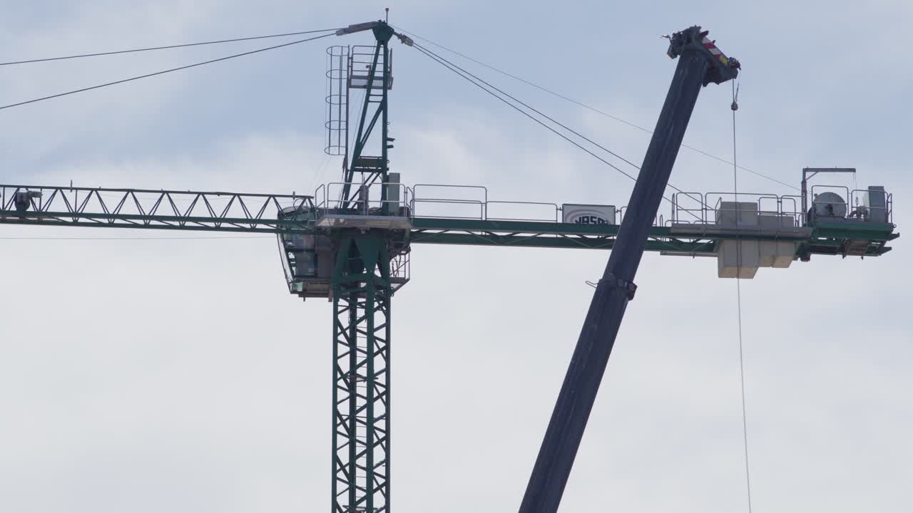 아르헨티나의 건설 현장에서 건설 크레인, 배경에는 고층 건물이 있습니다.